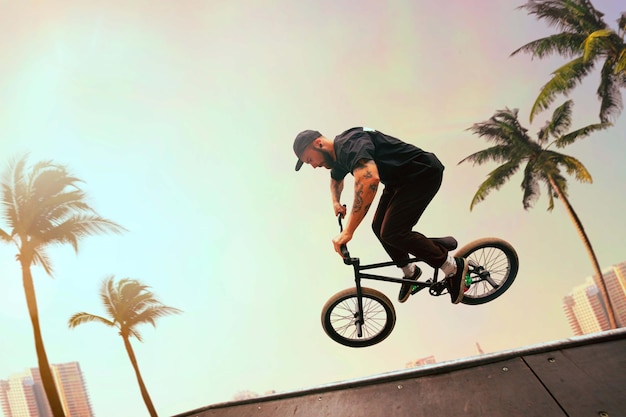BMX-rijder voert trucs uit in het skatepark bij zonsondergang