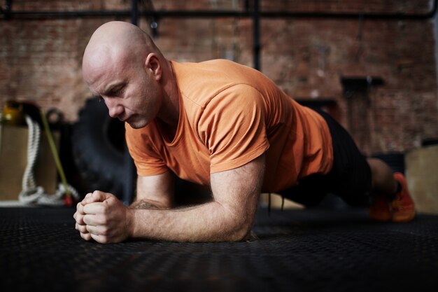 Bodybuilder die zich in plank bevindt