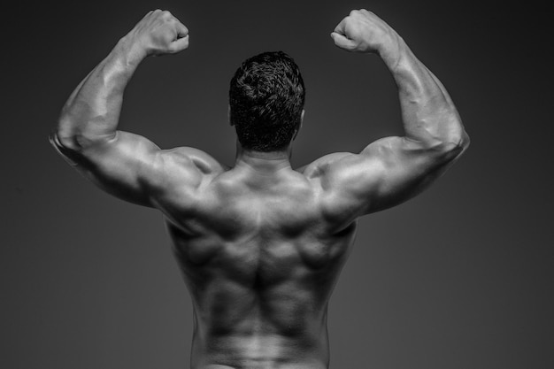 Gratis foto bodybuilder poseren in studio. geïsoleerd op grijze achtergrond.