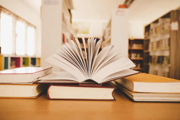 Boek in de bibliotheek met oud open tekstboek, stapel stapels tekstarchief van de literatuur op de leestafel