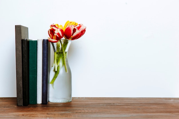 Boeken in de buurt van vaas met bloemen