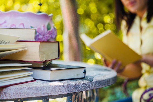 Boeken op tafel en vrouw lezen