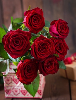 Boeket rode rozen op een houten tafel.