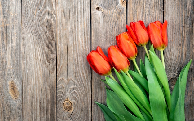 Boeket van rode tulpen op een houten bovenaanzicht als achtergrond