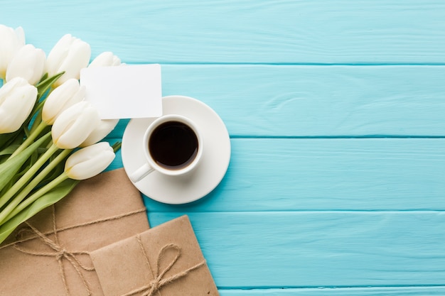Boeket van tulpenbloemen met koffie en verpakt papier
