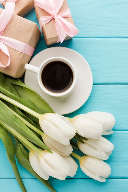 Boeket van tulpenbloemen met kopje koffie en geschenken