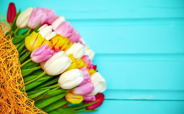 Boeket van verse veelkleurige tulpenbloemen op oude blauwe houten tafel