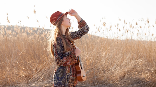 Boheemse vrouw in het veld met ukelele