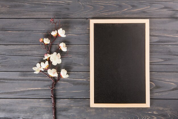 Boomtak met witte bloemen en leeg bord op tafel