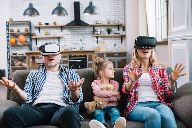 Gratis foto boos meisje die haar ouders kijken terwijl moeder die virtuele werkelijkheidsglazen thuis draagt