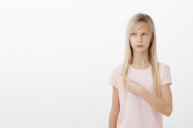 Boos schattig beledigd meisje wijzende linkerbovenhoek, boos kijken