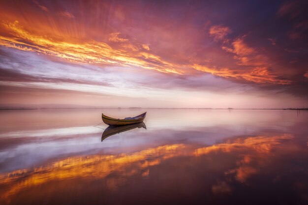 Boot in een meer bij zonsondergang