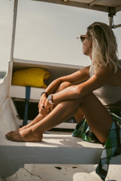Boottocht op Bali. Een jonge vrouw met zonnebril vaart op een boot naar een nabijgelegen eiland.