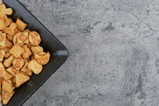 Bord vol met droge gezouten crackers op marmer.