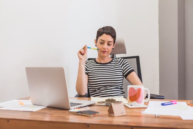 Bored werknemer op zoek naar haar laptop