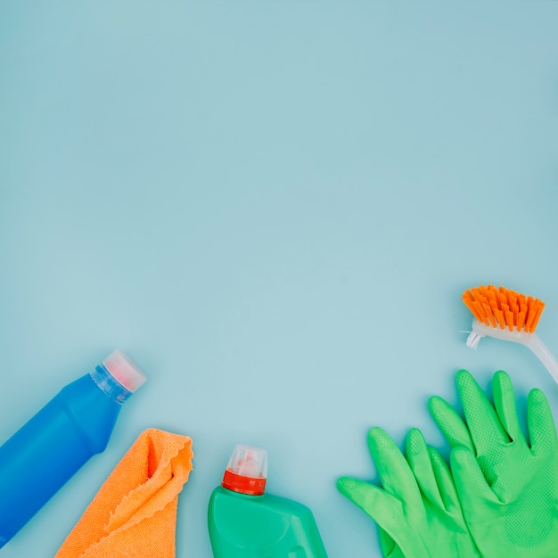 Borstel; groene handschoenen; servet en fles op blauwe achtergrond