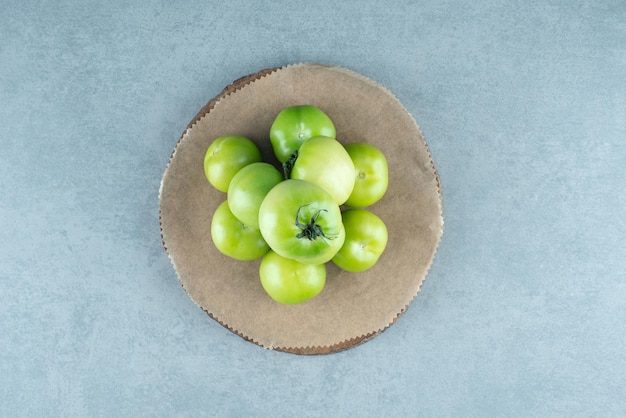 Bos van groene tomaten op houten stuk.