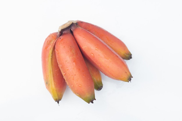 Bos van rijpe cavendish-banaan of rood bananenfruit op witte lijst en witte achtergrond