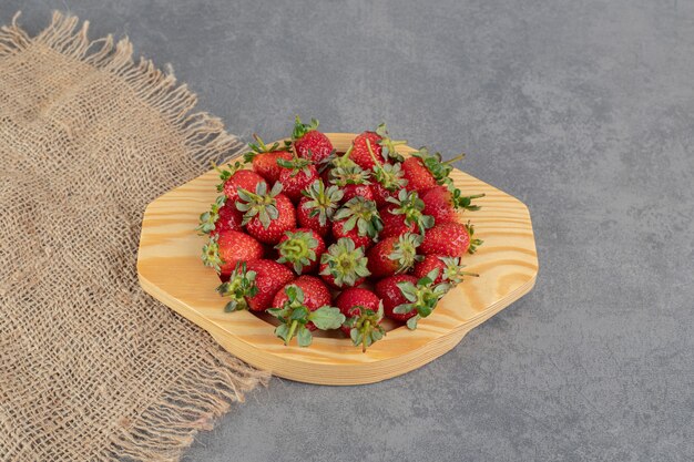 Bos van rode aardbeien op houten plaat. Hoge kwaliteit foto