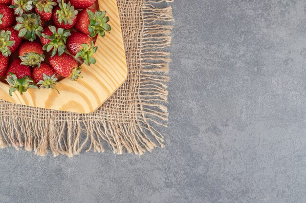 Bos van rode aardbeien op houten plaat. Hoge kwaliteit foto