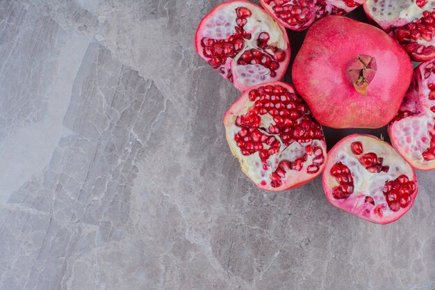 Bos van rode granaatappels op stenen achtergrond.