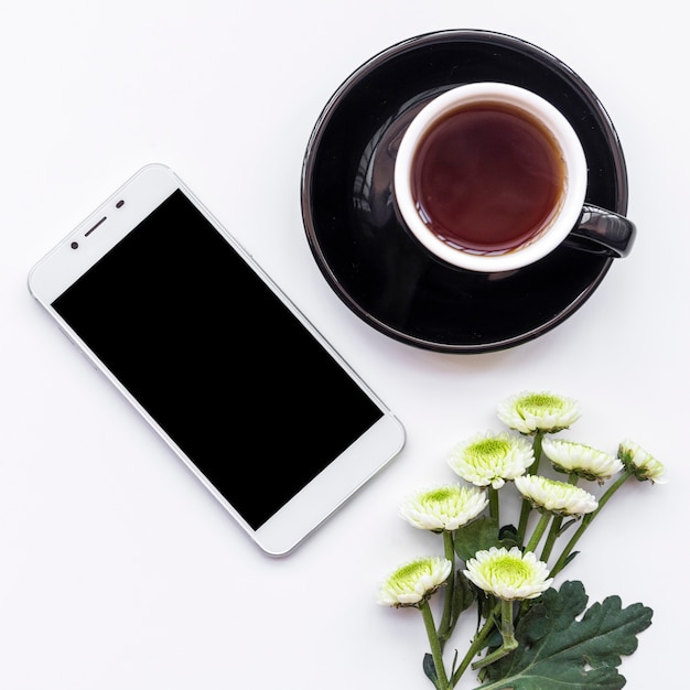 Bos van verse bloemen met een kopje koffie en smartphone