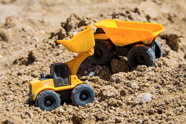 Bouwmachines speelgoed op het zand in zonnige dag gele en zwarte kleuren speelgoed bouwspeelgoed