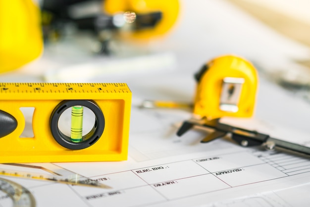 Gratis foto bouwplannen met helm en tekengereedschap op blauwdrukken.