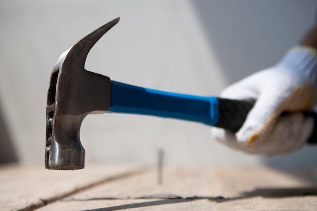 Gratis foto bouwvakker die hamer gebruikt op de bouwplaats