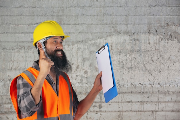 Bouwvakker met document, plan werken voor de binnenkant bouwconstructieplaats.