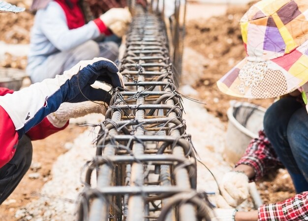 bouwvakkers installeren stalen staven in balken van gewapend beton