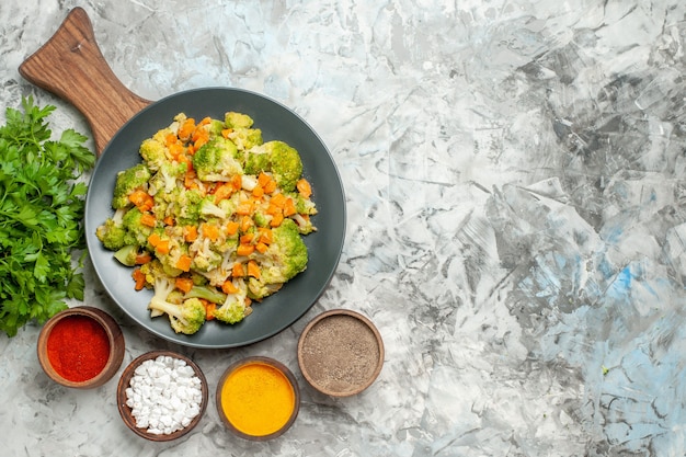 Boven weergave van gezonde plantaardige salade verschillende kruiden en broccoli op witte tafel