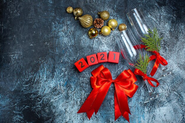 Boven weergave van glazen bekers met rood lint en nummers decoratie accessoires op donkere achtergrond