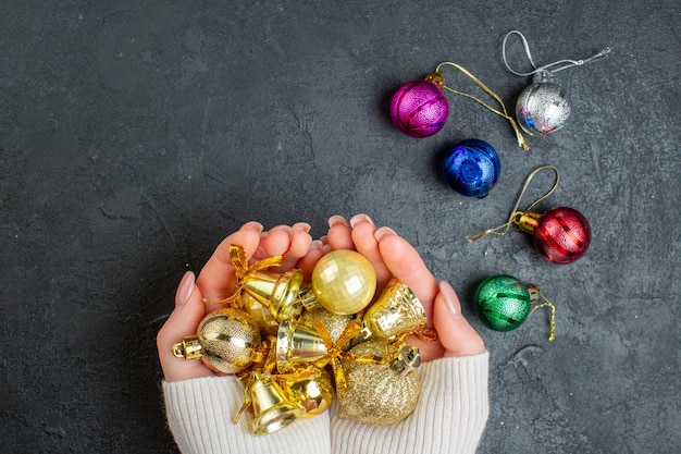 Boven weergave van hand met kleurrijke decoratieaccessoires op donkere achtergrond