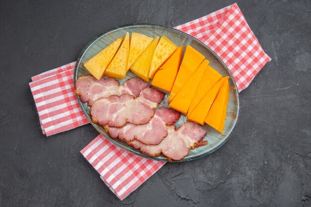 Boven weergave van heerlijke snacks op rode halfgevouwen gestripte handdoek op een zwarte achtergrond