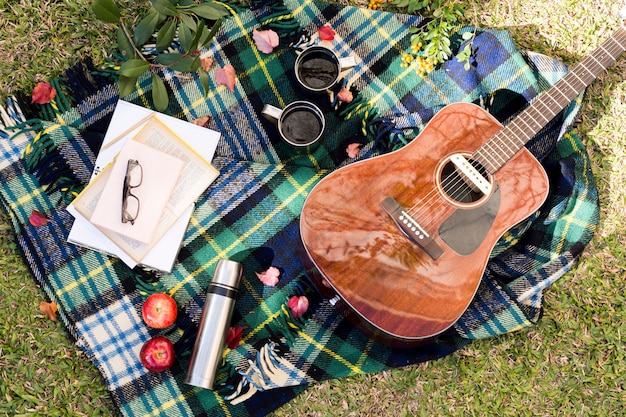 Bovenaanzicht akoestische gitaar op picknick doek