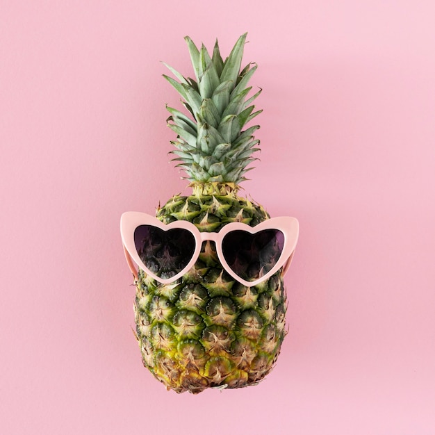 Bovenaanzicht ananas met hartvormige zonnebril