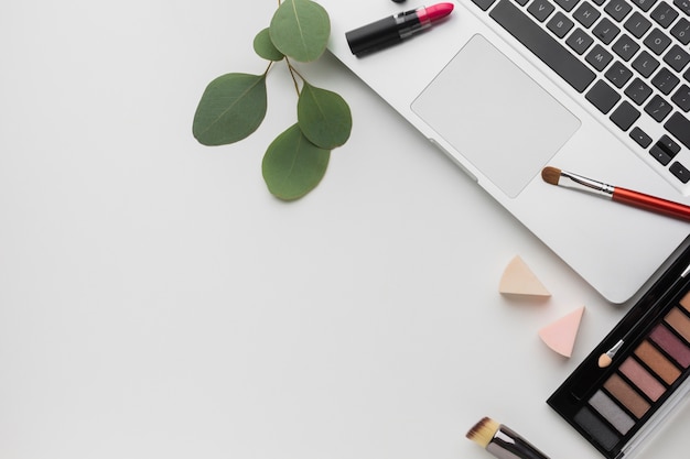 Gratis foto bovenaanzicht arrangement met laptop en make-up palet