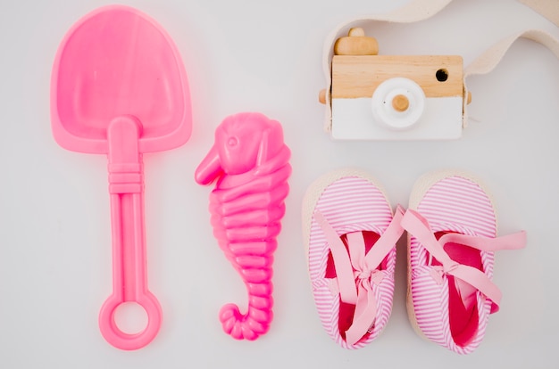 Bovenaanzicht baby schoenen met roze speelgoed
