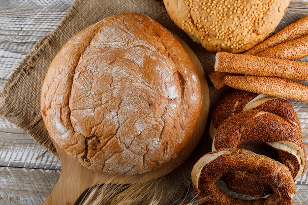 Bovenaanzicht bakkerijproducten met gerst op snijplank en woooden oppervlak. horizontaal