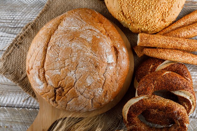 Bovenaanzicht bakkerijproducten met gerst op snijplank en woooden oppervlak. horizontaal