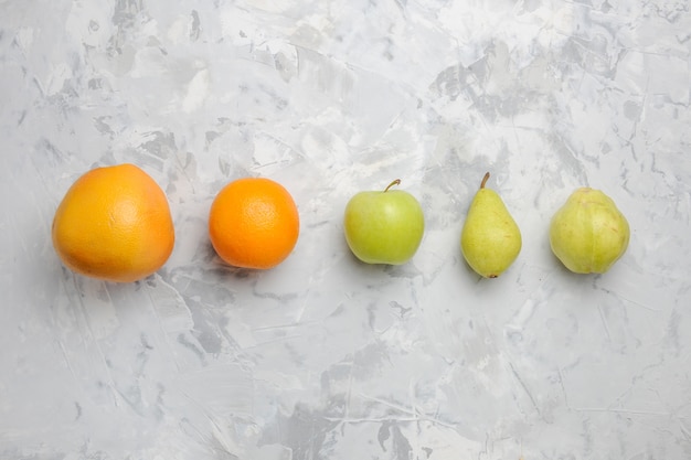 Bovenaanzicht bekleed vers fruit peren en mandarijnen op witte achtergrond