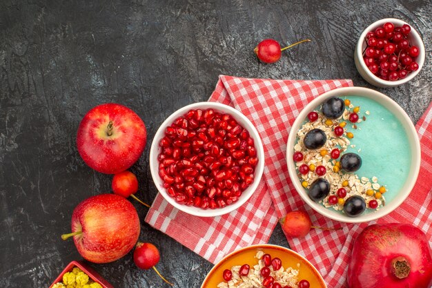 Bovenaanzicht bessen schalen met bessen havermout appels snoepjes op het wit-roze tafelkleed