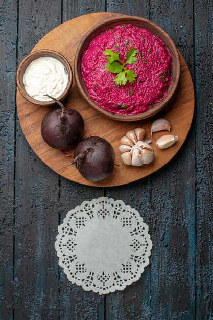 Bovenaanzicht bietensalade met zure room en knoflook op donker bureau