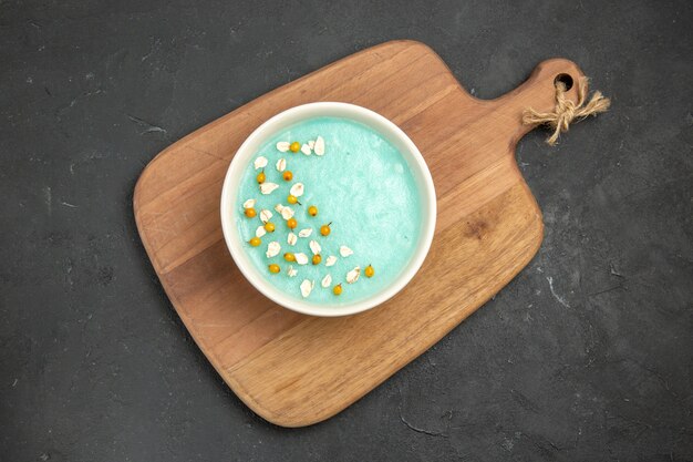 Bovenaanzicht blauw iced dessert in plaat op donkere tafel ijs kleur crème