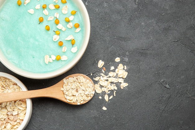 Bovenaanzicht blauw ijsdessert met rauwe muesli op donkere tafelfoto melkgraan