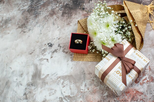 Bovenaanzicht bloemboeket ring in kleine doos cadeau op tafel met vrije ruimte