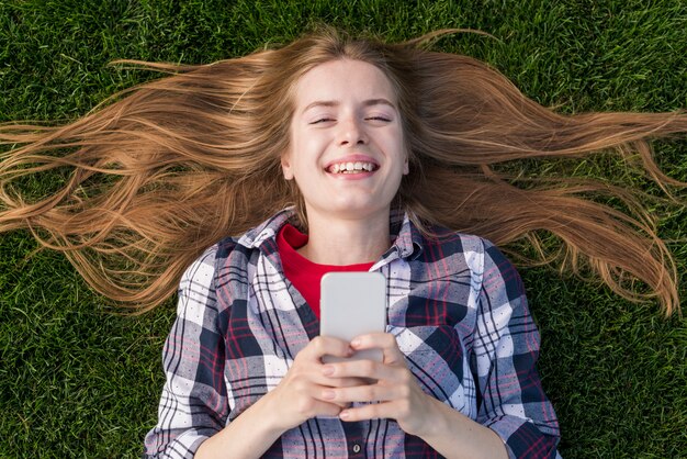 Bovenaanzicht blonde meisje houdt van haar telefoon