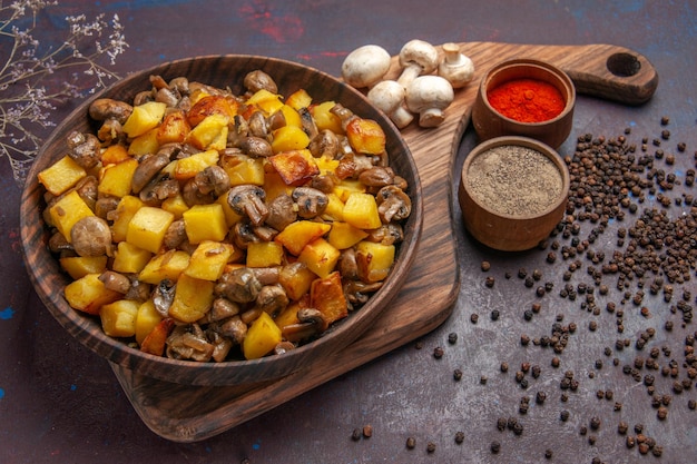 Bovenaanzicht bord met voedselbord met aardappelen met champignons, witte champignons en kleurrijke kruiden
