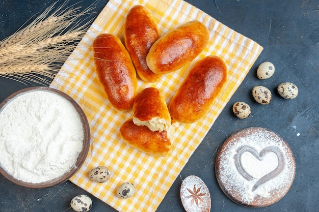 Gratis foto bovenaanzicht breakfat rolt op keukenpapier meel kom kwarteleitjes hart afdruk in poedersuiker op tafel